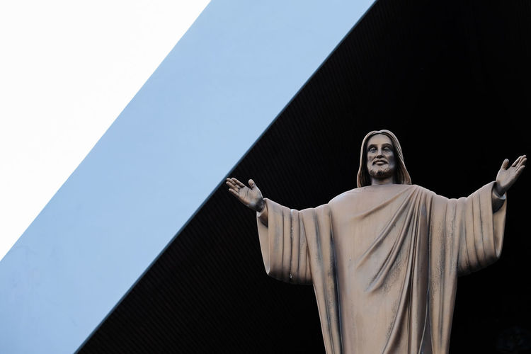 Low angle view of statue against building against clear sky