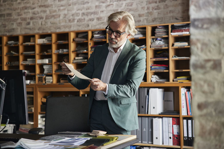 Male design professional examining fabric in office
