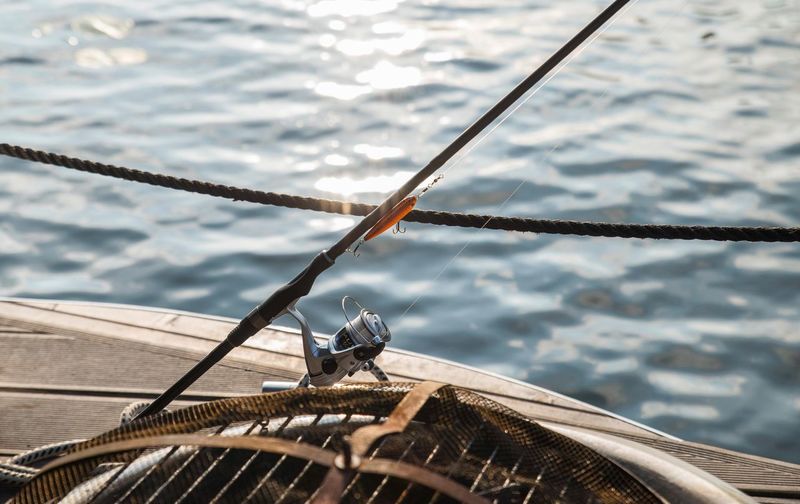 High angle view of fishing rod in boat against sea