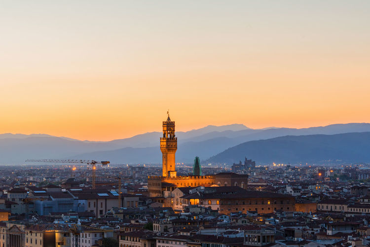 Illuminated buildings in florence city against sky during sunset
