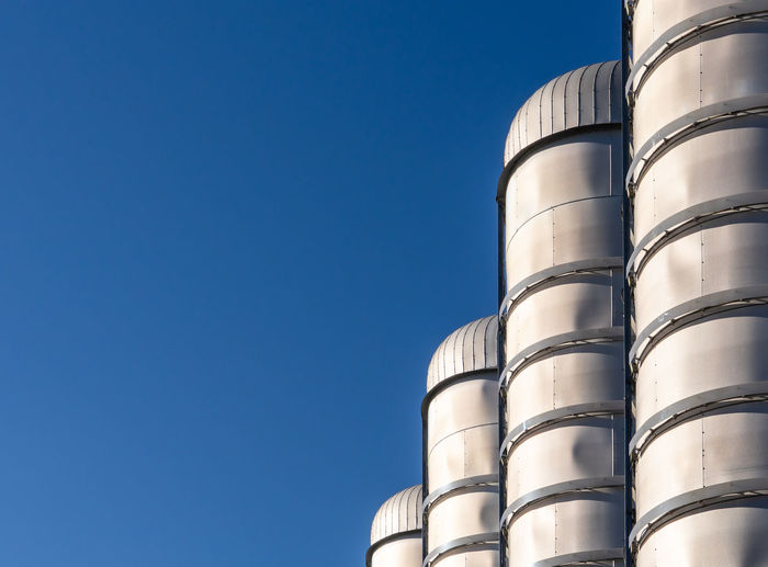Low angle view of factory against clear blue sky