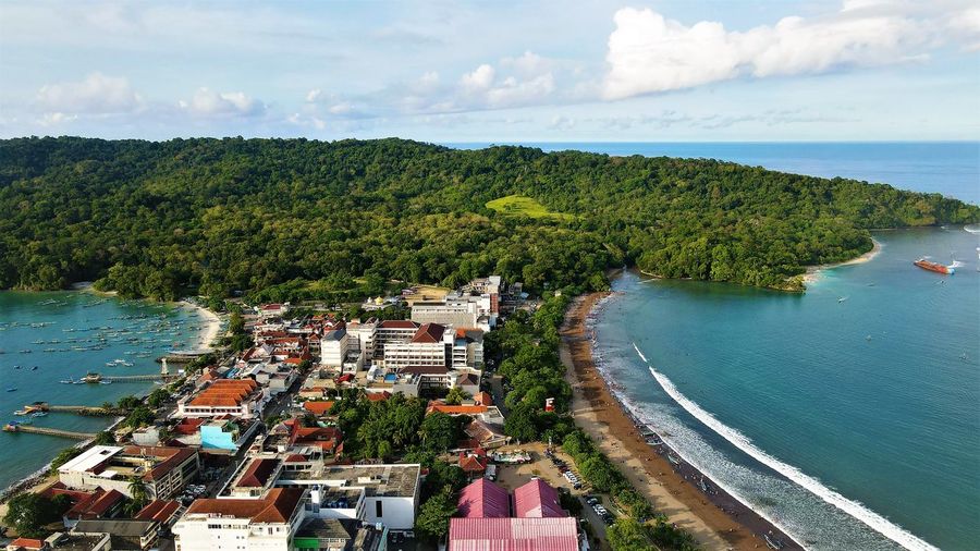 High angle view of townscape by sea against sky