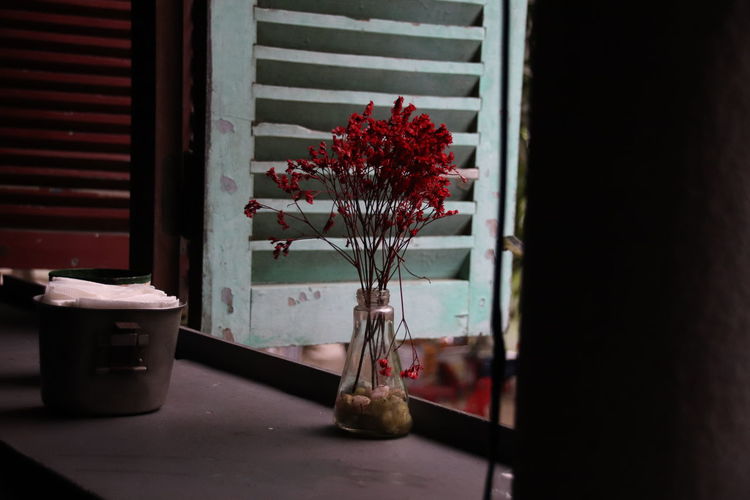 Close-up of flower vase with flower on the window sill of a cafe
