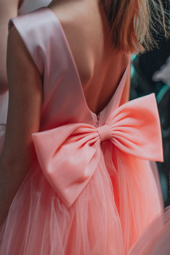 Details of a baby pink dress with a pretty bow on the back