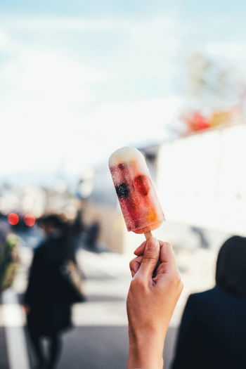 Close-up of hand holding popsicle