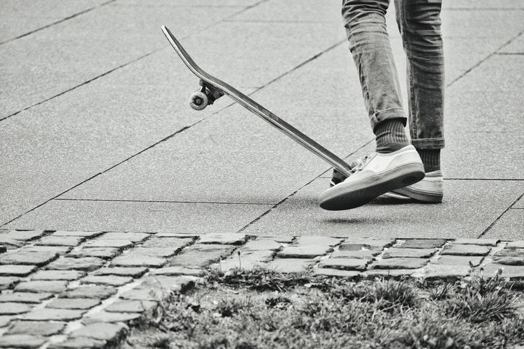 Low section of man skateboarding on footpath