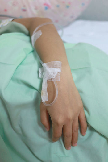 Midsection of woman lying on hospital bed
