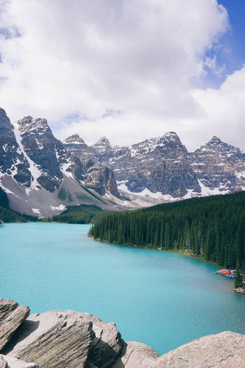 Scenic view of lake by mountains against sky