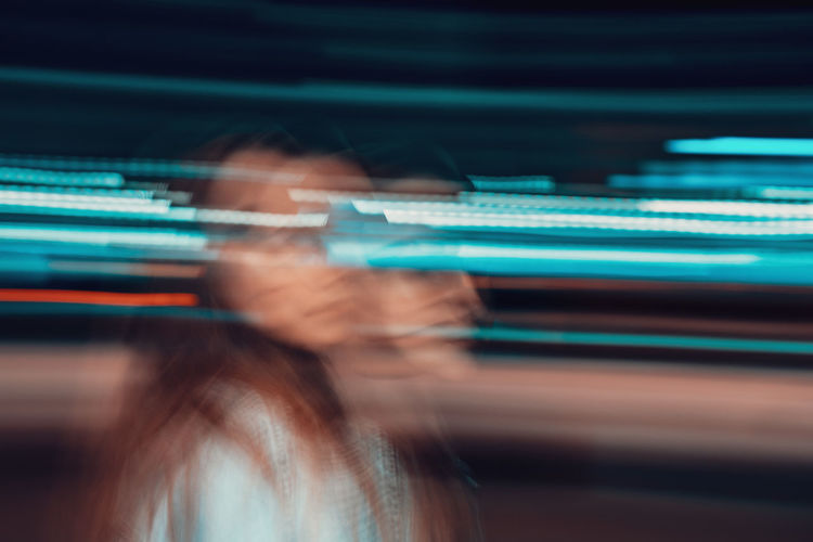 Double exposure image of woman and light trails