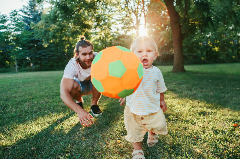 Full length of father and son playing in grass