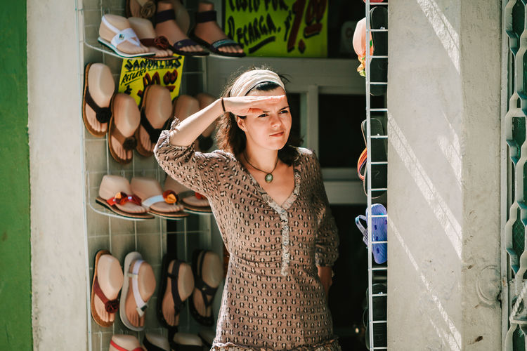 Saleswoman peeking out of store looking for buyers