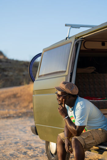 Black african american man sitting in his camper van thoughtfully