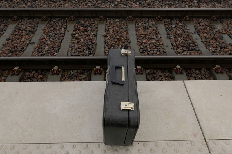 High angle suitcase on railroad platform