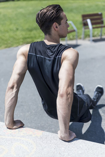 Side view of young man exercising in gym