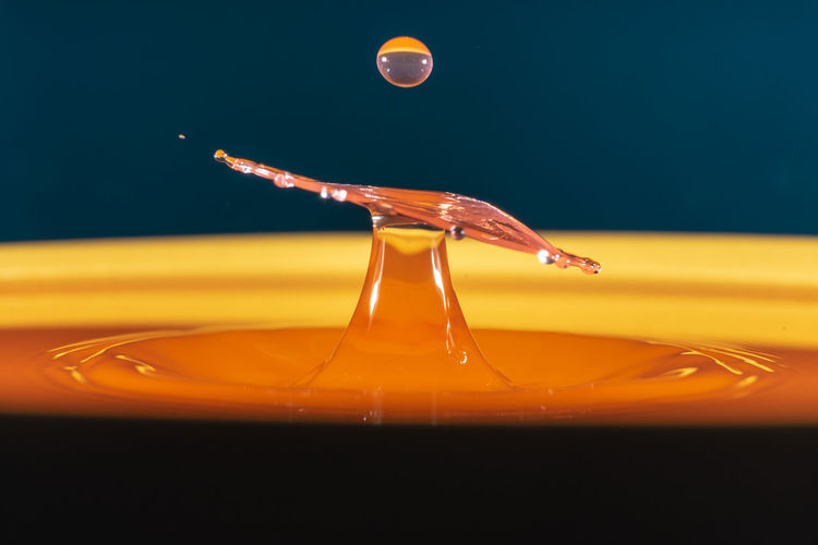 Close-up of yellow water splashing on glass