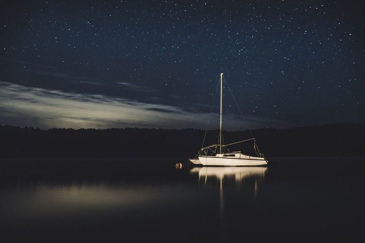 Sailboat on sea against sky at night
