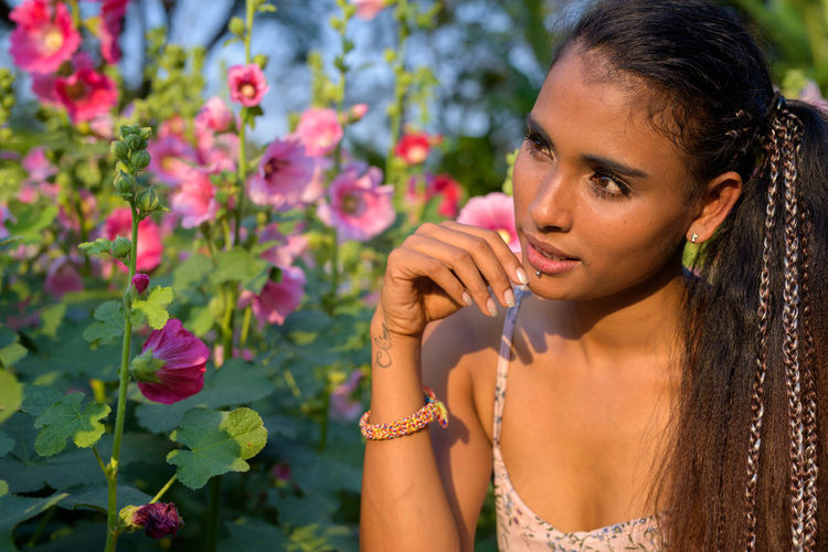 Woman looking at flower outdoors
