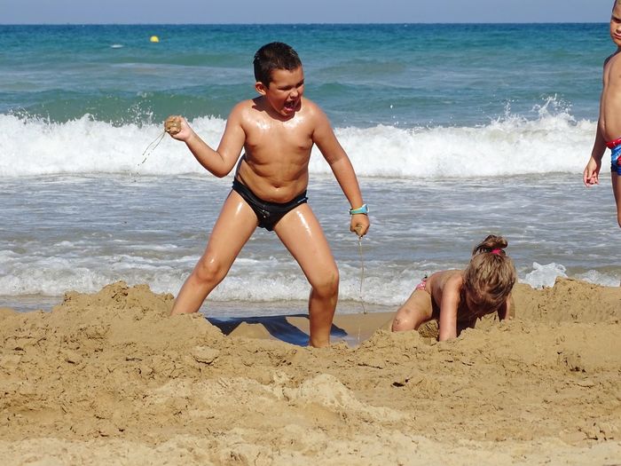 Full length of shirtless boy on beach