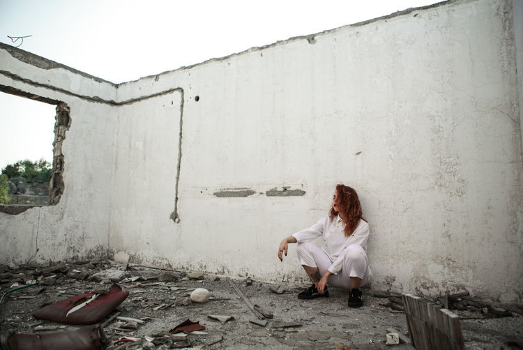 Young woman sitting in abandoned house