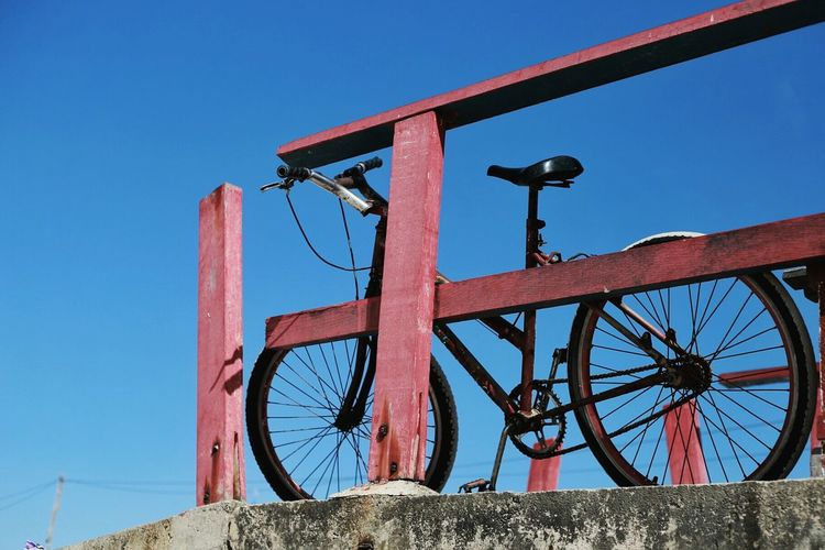 Low angle view of a bicycle against clear blue sky
