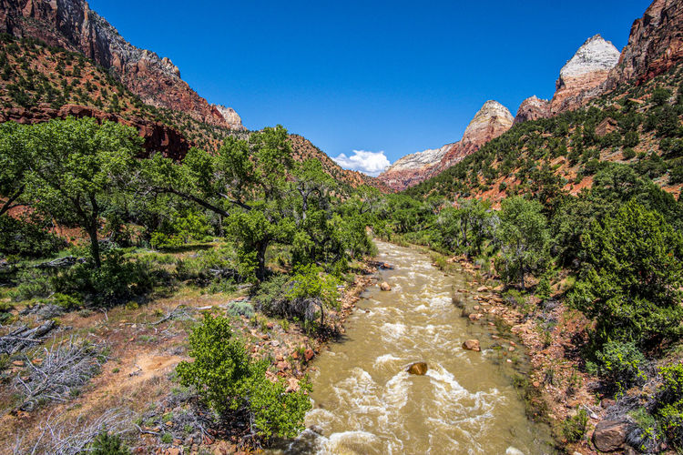 Scenic view of river amidst mountains against clear sky