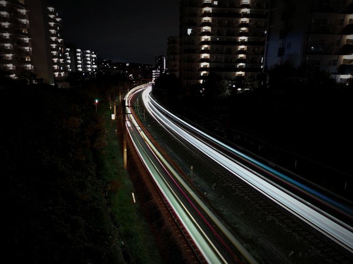 High angle view of light trails on street amidst buildings in city