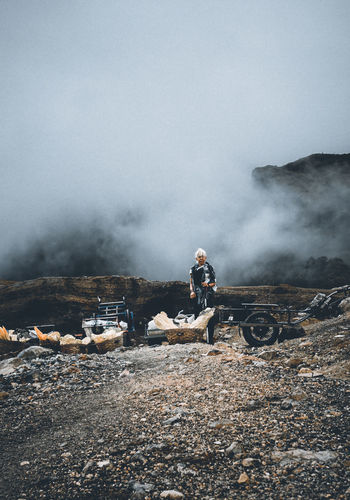 People standing on mountain against sky