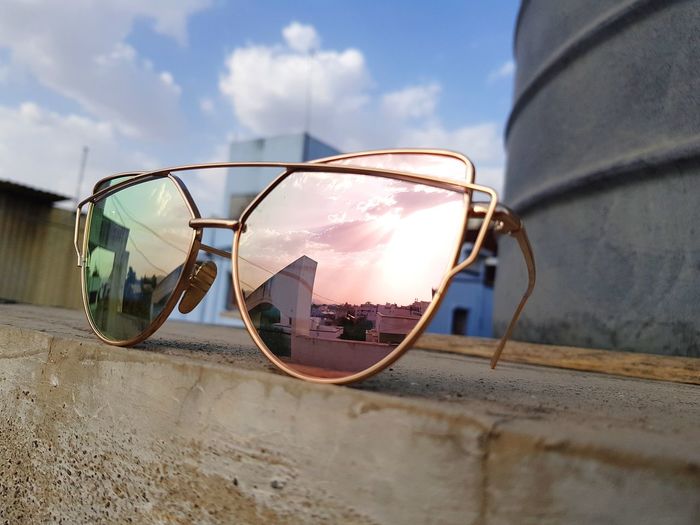 Close-up of sunglasses against sky
