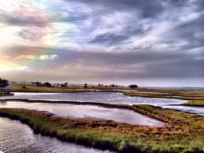 Scenic view of lake against cloudy sky