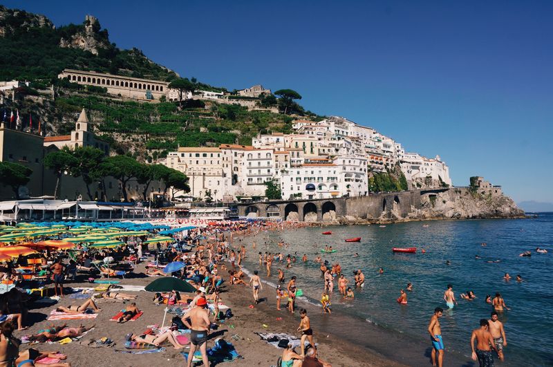 People at beach against houses in amalfi coast