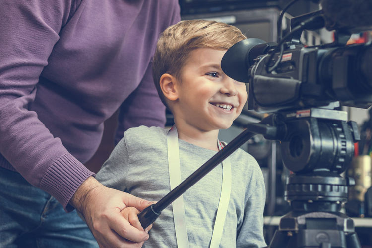 Boy with grandfather using television camera