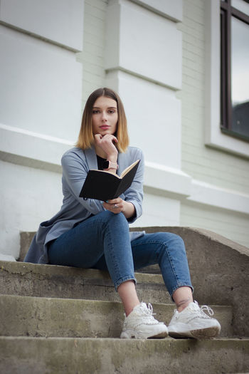 Young woman using laptop while sitting on steps