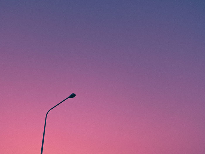Low angle view of street light against pink wall