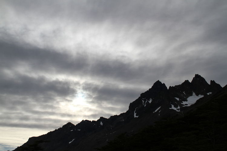 Low angle view of mountain against cloudy sky during sunset