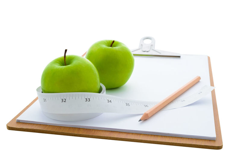 Close-up of apples on table against white background