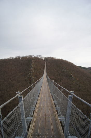 Empty footbridge against sky