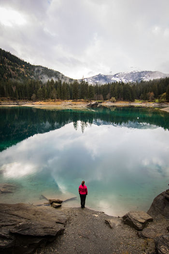 Woman standing by lake at forest