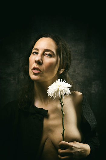 Woman in melancholic attitude with white chrysanthemum xiii