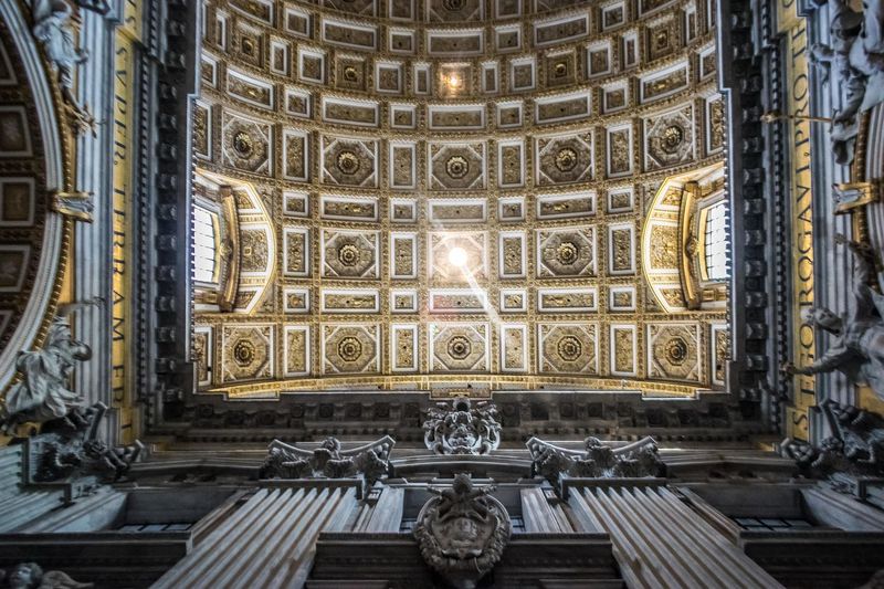 Low angle view of ceiling design in st. peter's basilica, vatican city, italy. gold patterns. 