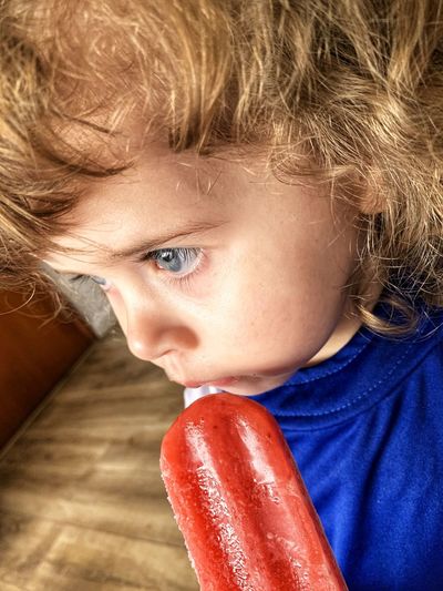 Blue-eyed girl getting ready to take popsicle.
