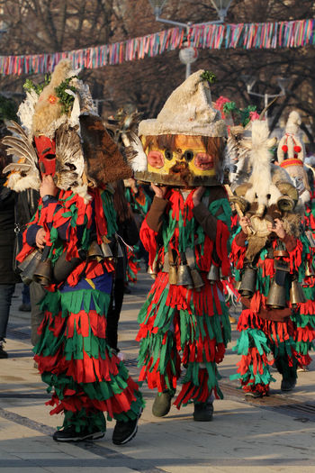 People in costume performing traditional dance on sidewalk