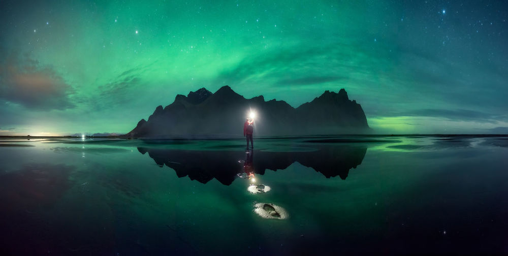 Scenic view of lake against sky at night