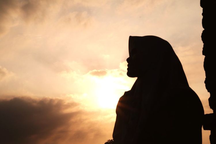 Silhouette hijab people against sky during sunset