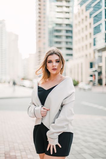 Beautiful young woman standing in city