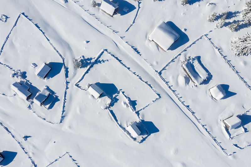 Snow covered remote village, homestead in the mountains. aerial drone view