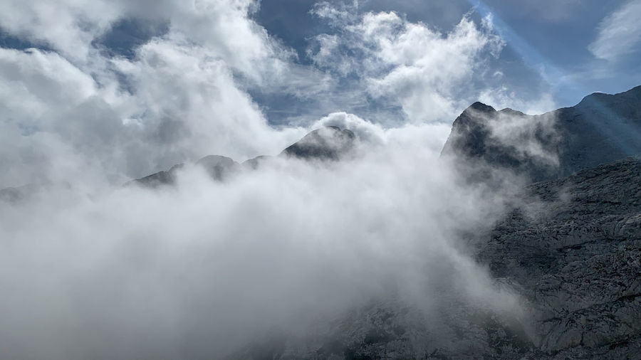 Scenic view of mountain range against cloudy sky