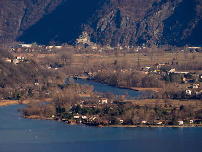 Scenic view of lake by city against mountain