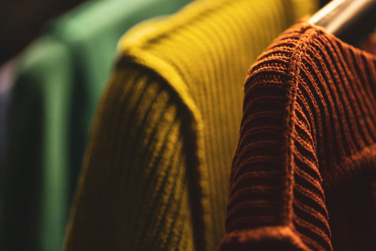 Close-up of sweaters hanging on rack at home