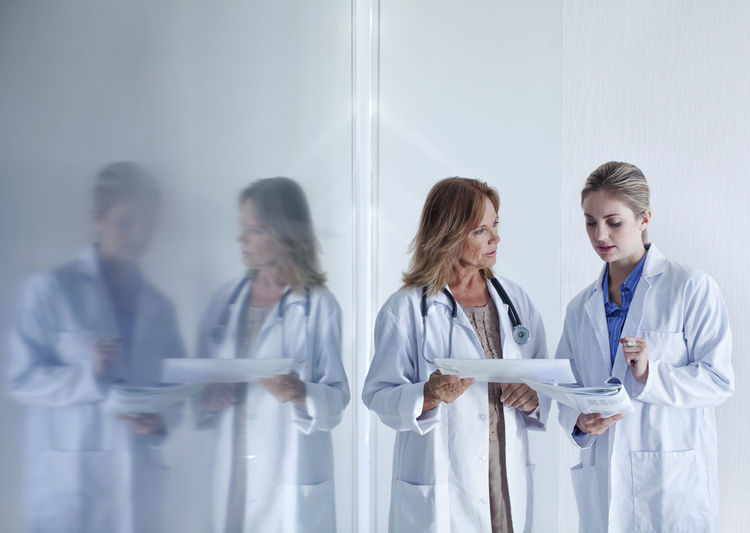 Female doctors discussing over documents in hospital