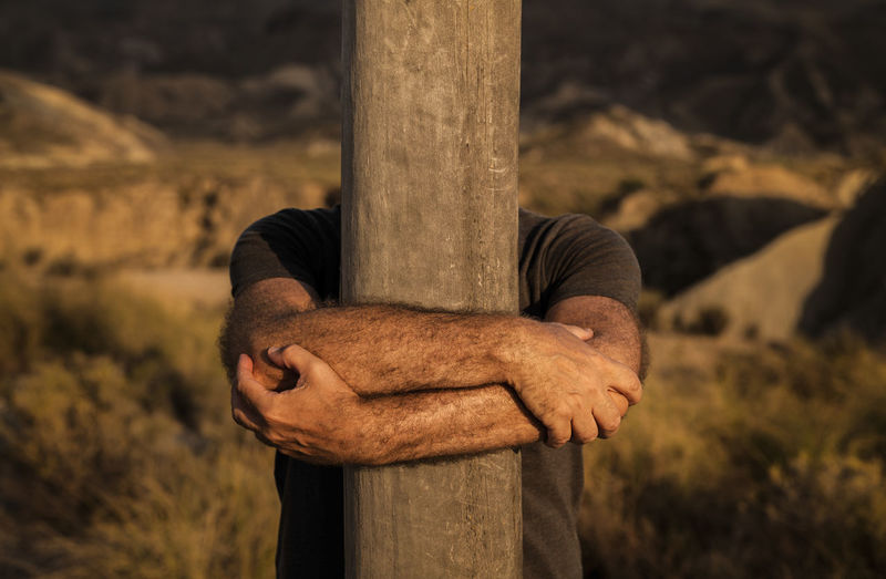 Man arm holding wooden column on tabernas desert in almeria, spain